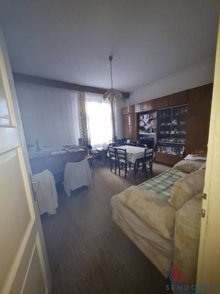 Living room in a family house with a coffee table, antique wall unit, and sofa.
