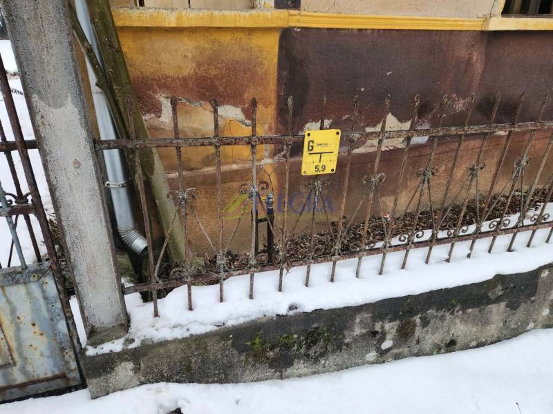 The fence of a family house in Felsőtelekes, covered with snow and with a gas sign.