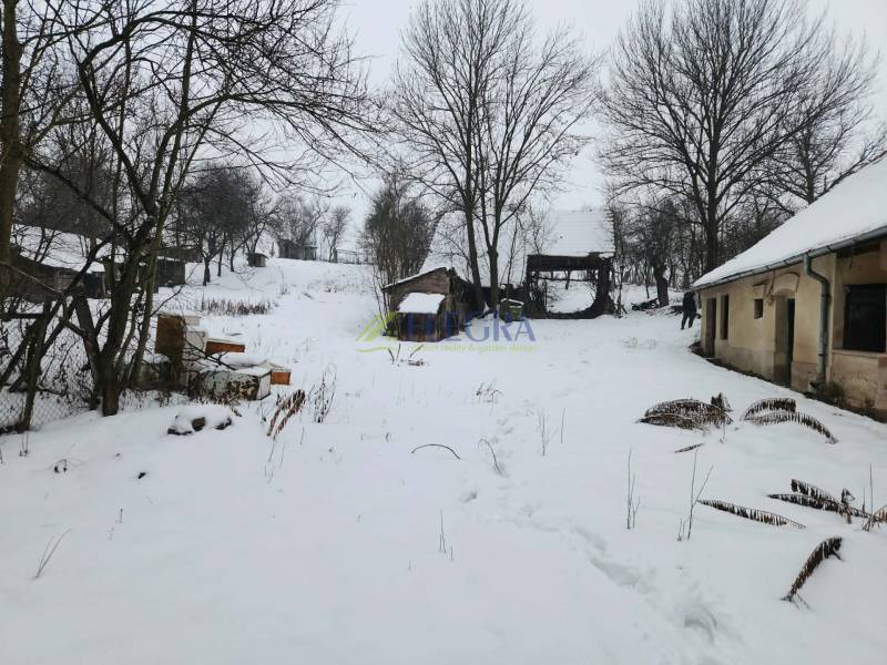 A snowy yard of a family house in Felsőtelekes with visible wooden structures.