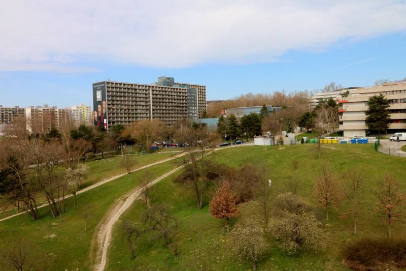 A view of Karlova Ves, Staré grunty with buildings surrounded by green areas and trees.