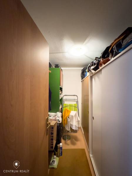 Storage space in a family house with sliding doors and steps, full of various items.