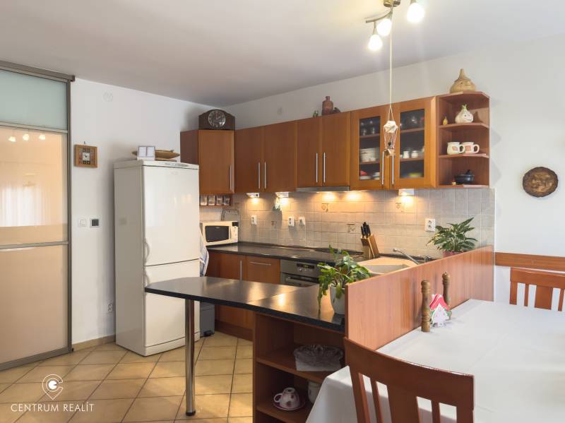 A kitchen in a family house with modern appliances and wooden cabinets.