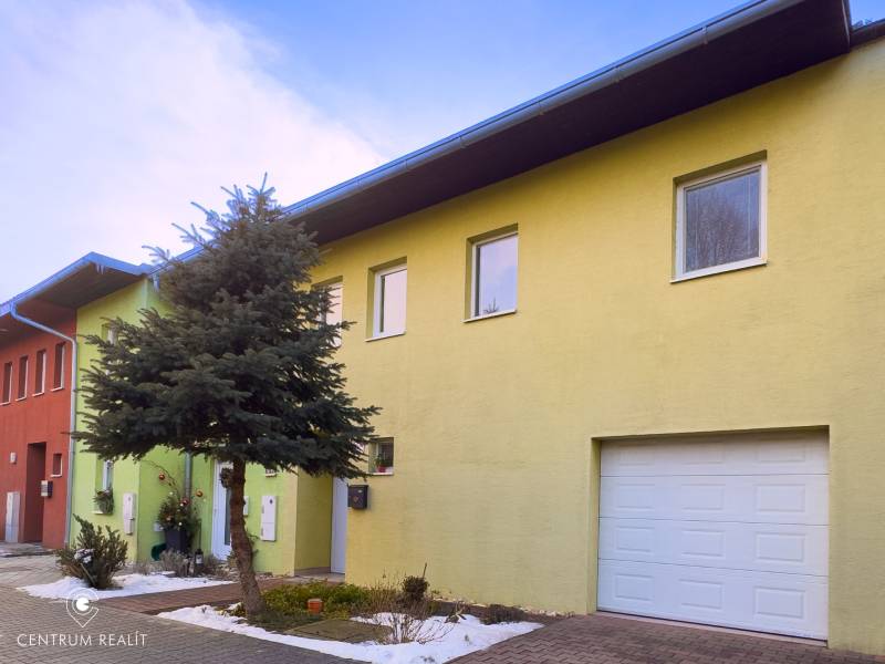 A family house on Hrabová Street in Hamuliakovo with a green facade and a garage.