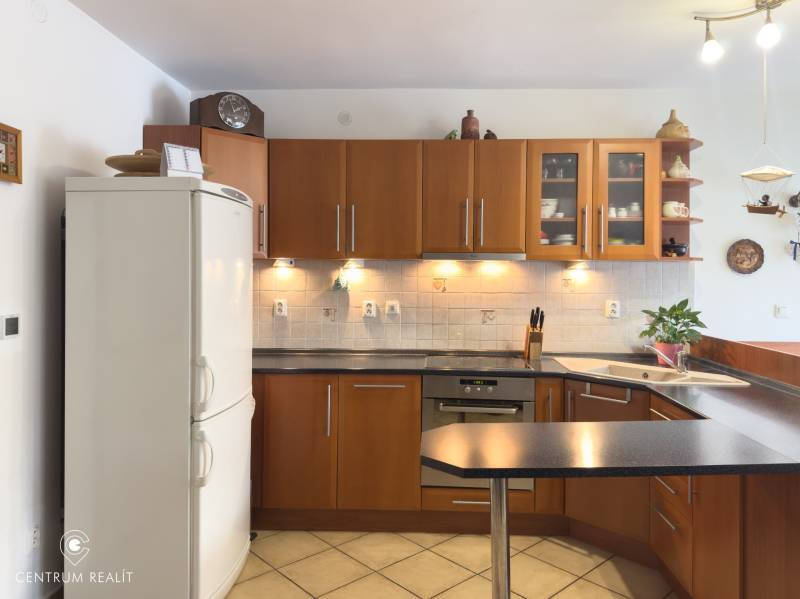 A kitchen in a family house with wooden cabinets and a white refrigerator.