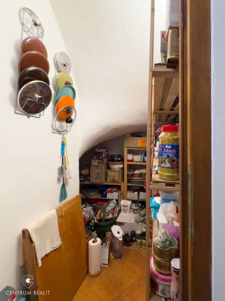 Pantry in a family house with shelves full of supplies and kitchen utensils.