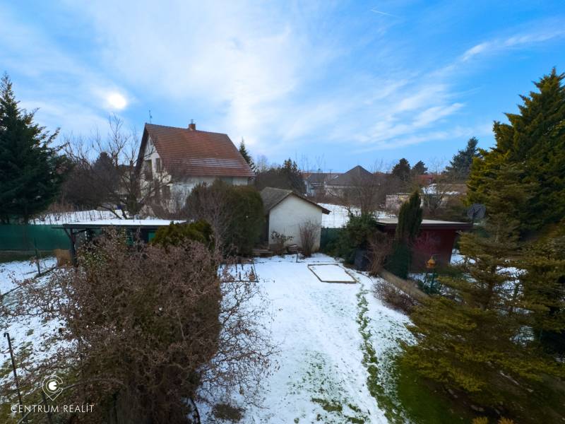 A snow-covered garden and vegetation near a family house on Hrabová Street in Hamuliakovo.
