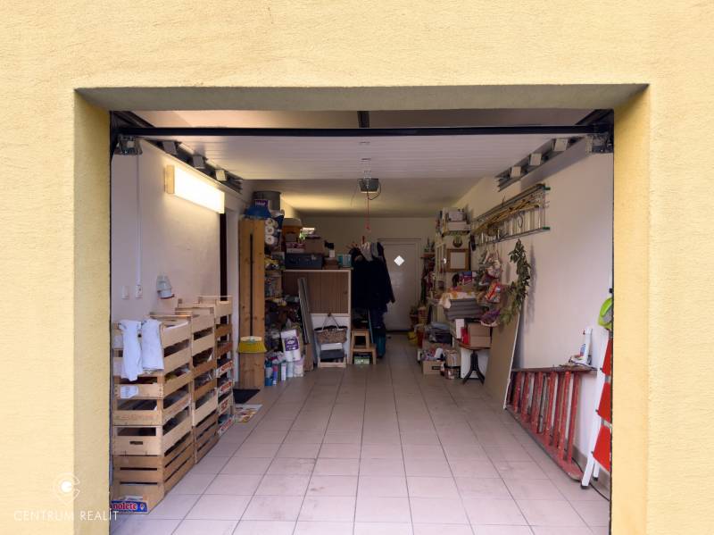 Garage in a family house with storage shelves and various items.