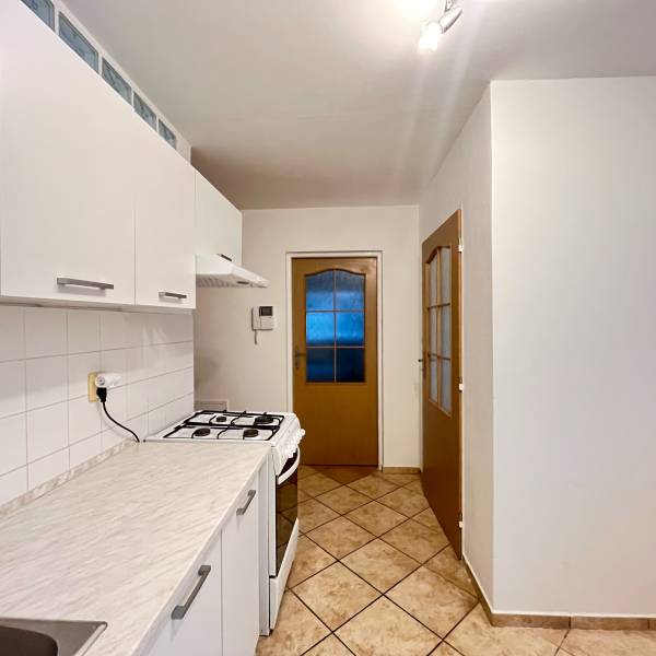 Kitchen in a studio apartment with white cabinets and a kitchen counter.