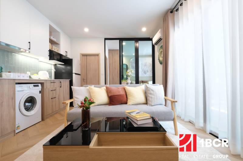 Living room of a two-room apartment with a wooden decor floor and cozy seating.