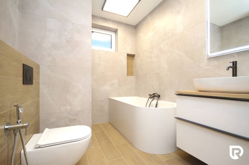 Bathroom with a bathtub, sink, and toilet, floor with wood decor.