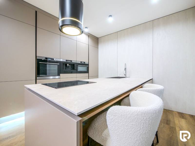 A kitchen in a family house with a cooktop and a floor with a wood decor.