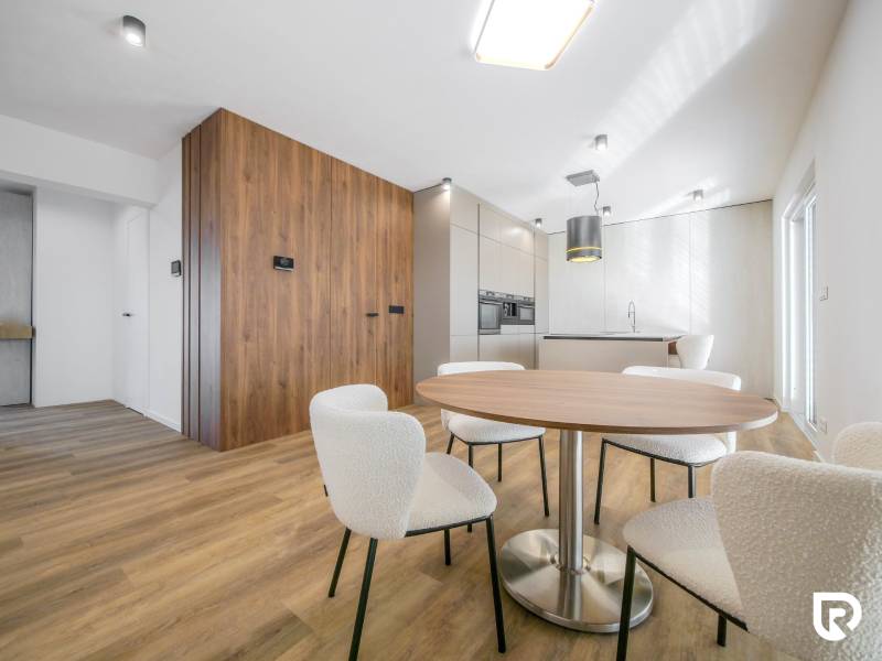 Dining room in a family house with a wooden decor floor and white chairs.