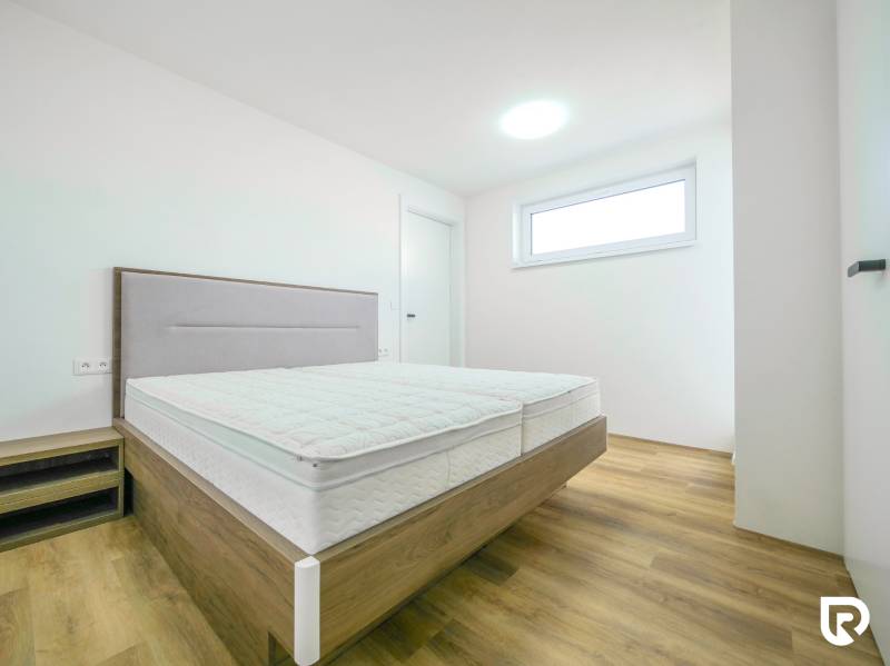 A bedroom in a family house with a bed and a wooden decor floor.