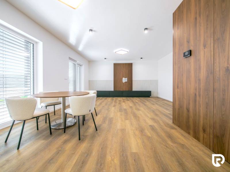 Interior of a family house with a wooden decor floor and a dining table with chairs.