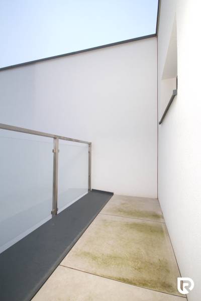 A balcony in a family house on Legionárska Street in Trenčín with glass railings.