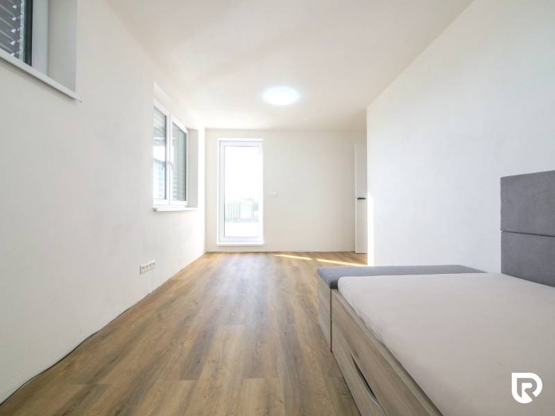 A room in a family house with a wooden decor floor and a sofa.