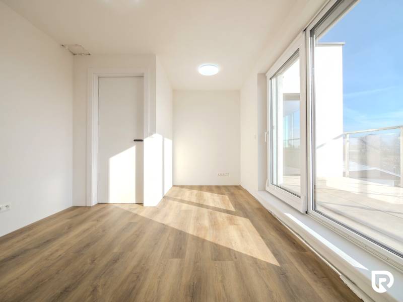 A room in a family house with a wooden decor floor and large windows.