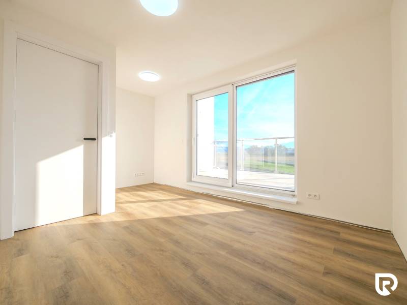 A bright room in a family house with a wooden decor floor and a large window.