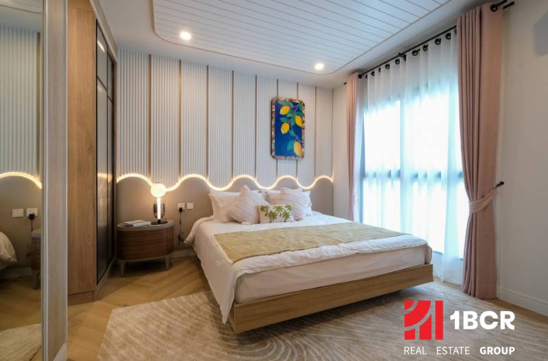 A bedroom in a 3-room apartment, with a wooden decor floor and light curtains.