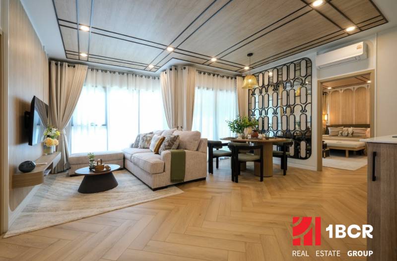 Living room in a 3-room apartment with a sofa, wall decor, and a wooden-patterned floor.