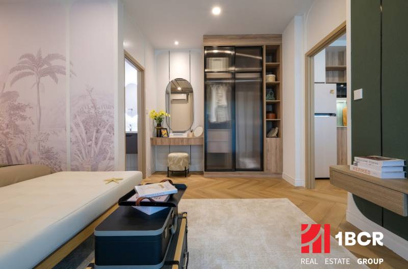 Interior of a 3-room apartment with a wooden decor floor, a mirror, and cozy seating.