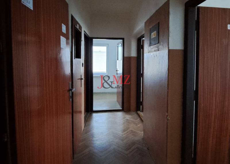 A hallway with doors in a family house, illuminated by natural light.