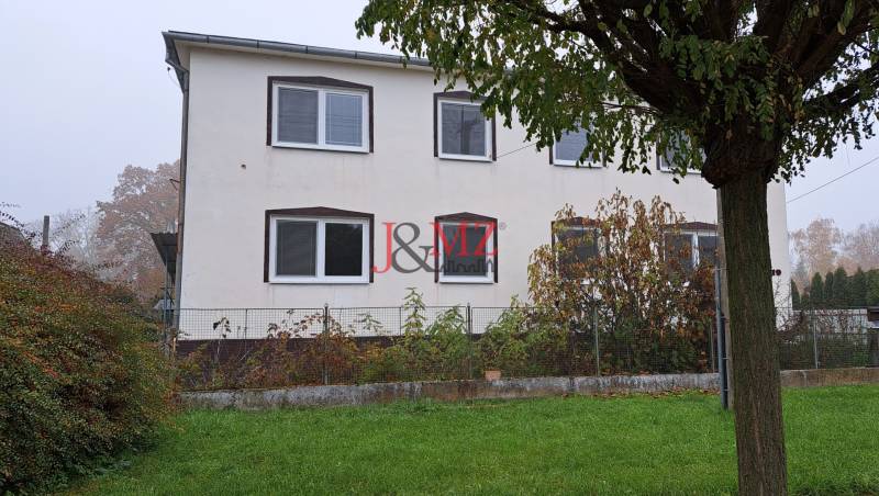 A family house in Kalná nad Hronom with a garden, a tree, and windows on the upper floor.