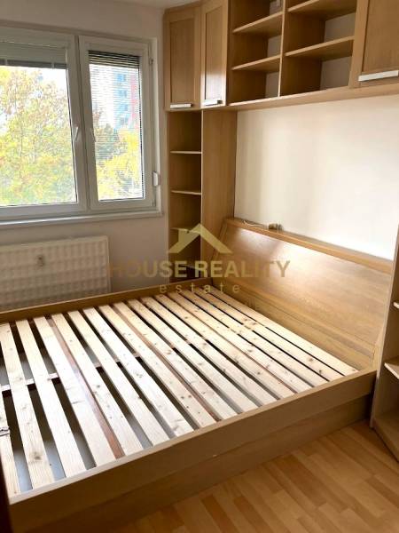 Bedroom in a 3-room apartment with a bed and built-in wardrobe, floor with wood decor.