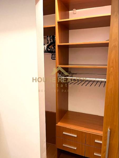 Built-in wardrobe with wood decor and drawers in a 3-room apartment.