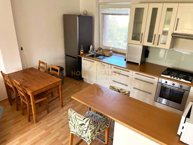 3-room apartment with a bright kitchen, dining table, and wooden decor flooring.