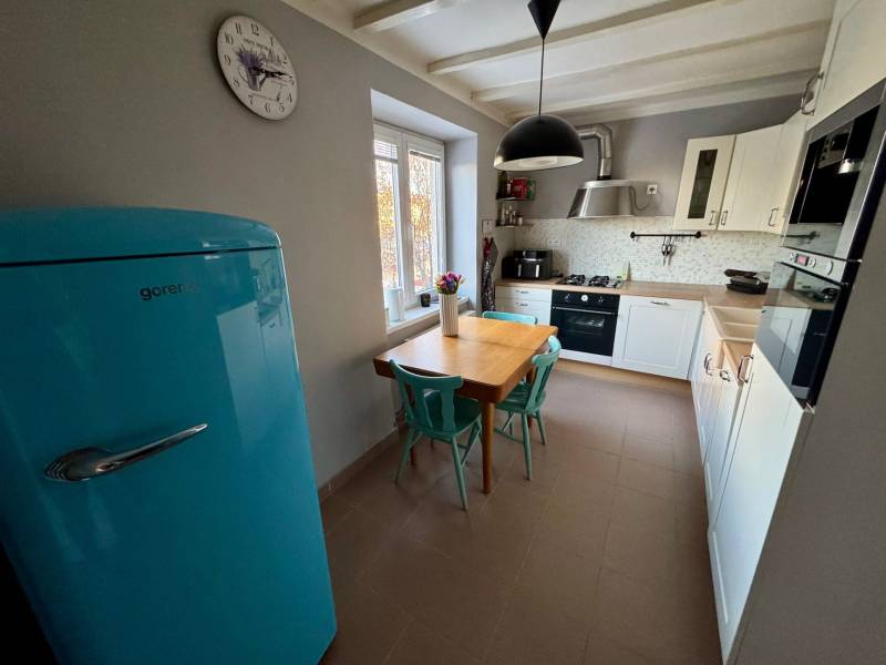 A kitchen in a 3-room apartment with a light blue refrigerator, table, and chairs.