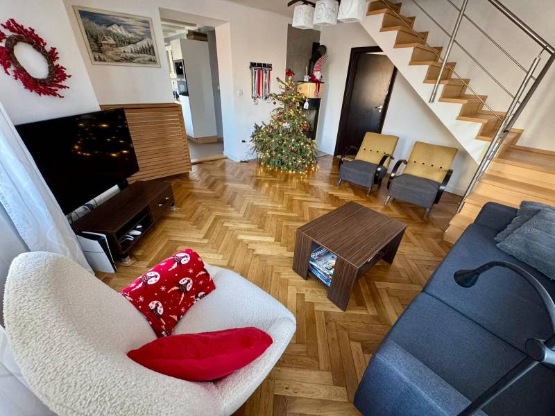 Living room in a 3-room apartment with a wood-patterned floor and a staircase.