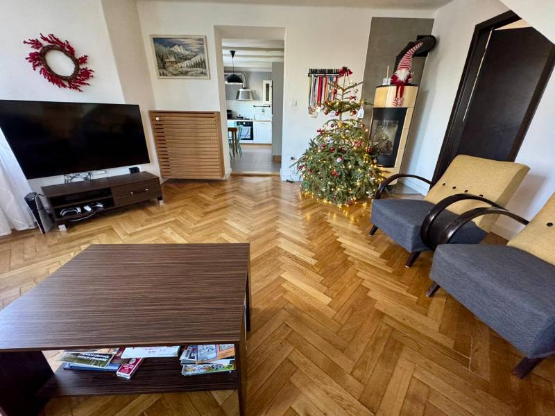Living room in a 3-room apartment with a Christmas tree and a wooden decor floor.