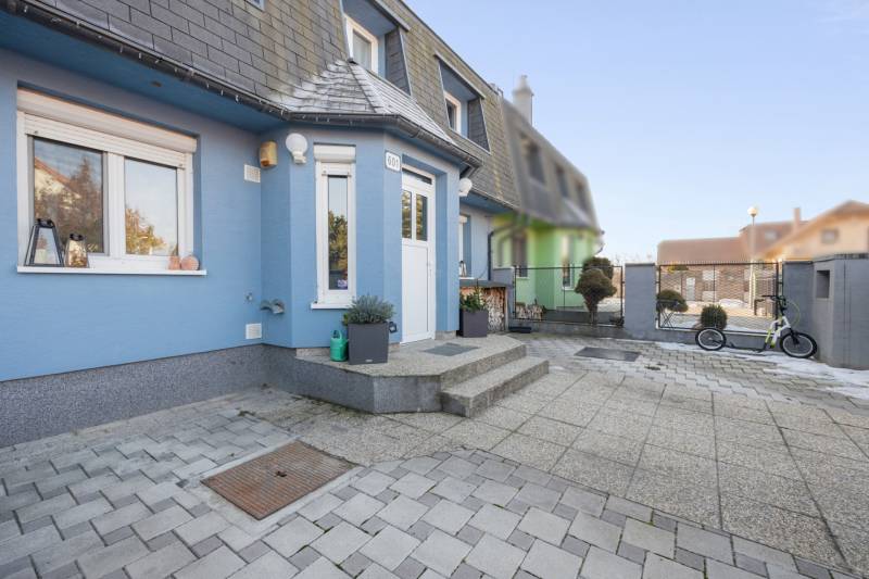 A family house on Južná Street in Miloslavov with a blue facade and a paved yard.