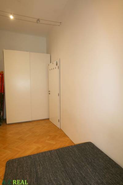A room in a 3-room apartment with a large wardrobe and a floor with a wooden decor.