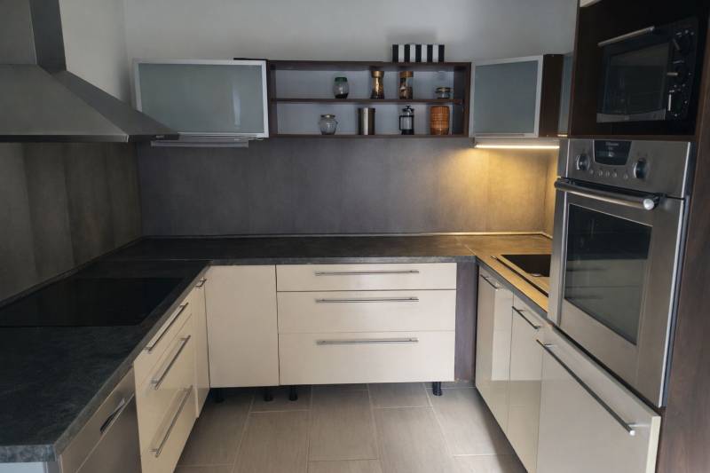 A kitchen unit in a family house with storage space and built-in appliances.