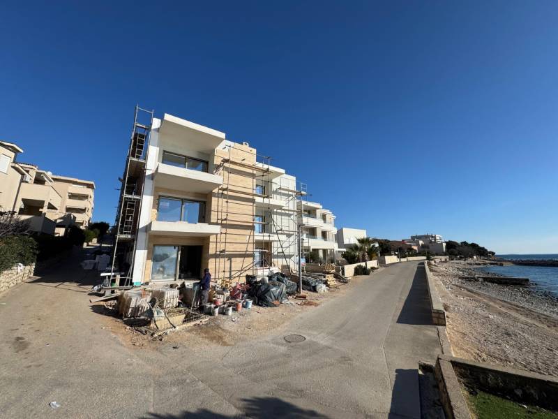 Seaside construction of 2-room apartments in Mandre by the sea, with scaffolding during construction.