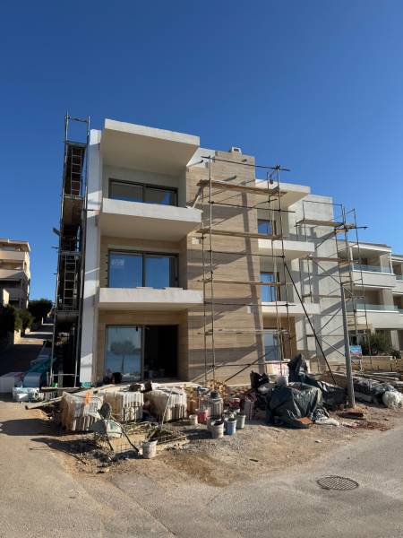 A new building in Mandre with 2-bedroom apartments, unfinished facade, scaffolding, and construction materials.