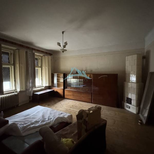 Living room in a family house with a wooden decor floor and a tiled stove.
