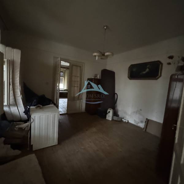A room in a family house with a wooden decor floor and older furnishings.