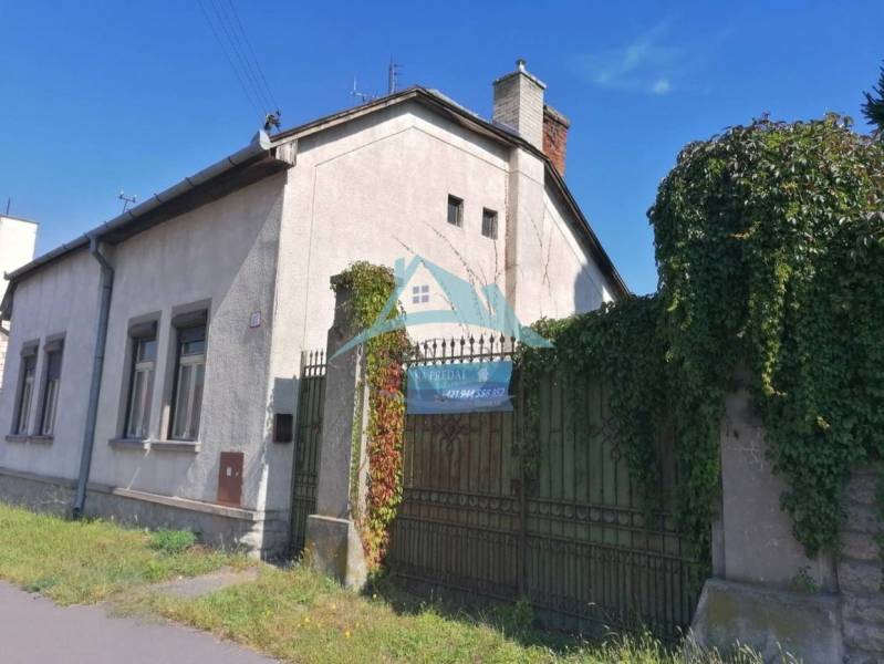 A family house on SNP Street in Šahy with a gate covered in greenery.