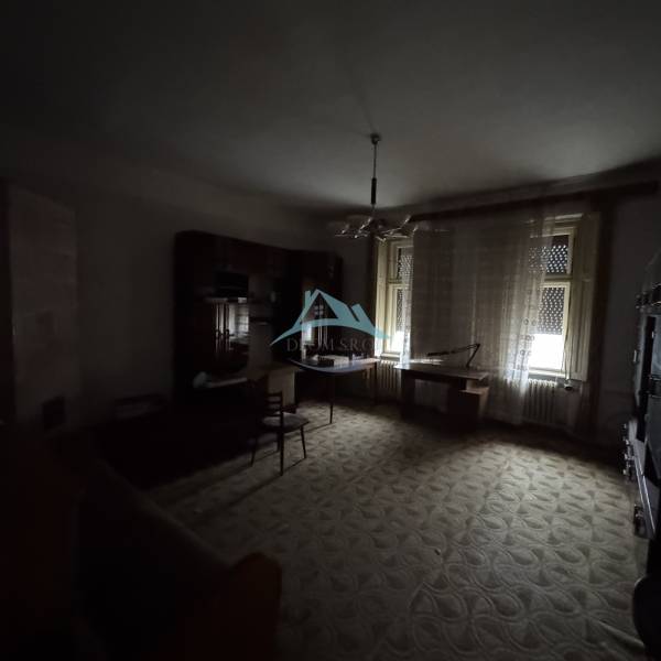 Dark living room, older furniture, carpet, curtains, and windows, family house.