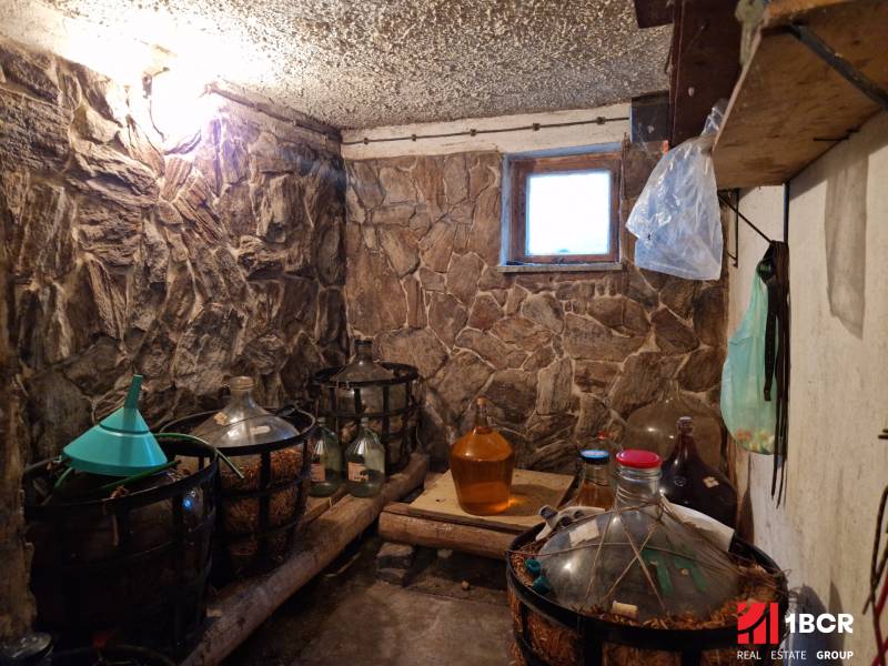 Stone walls of the cellar with demijohns in a family house.