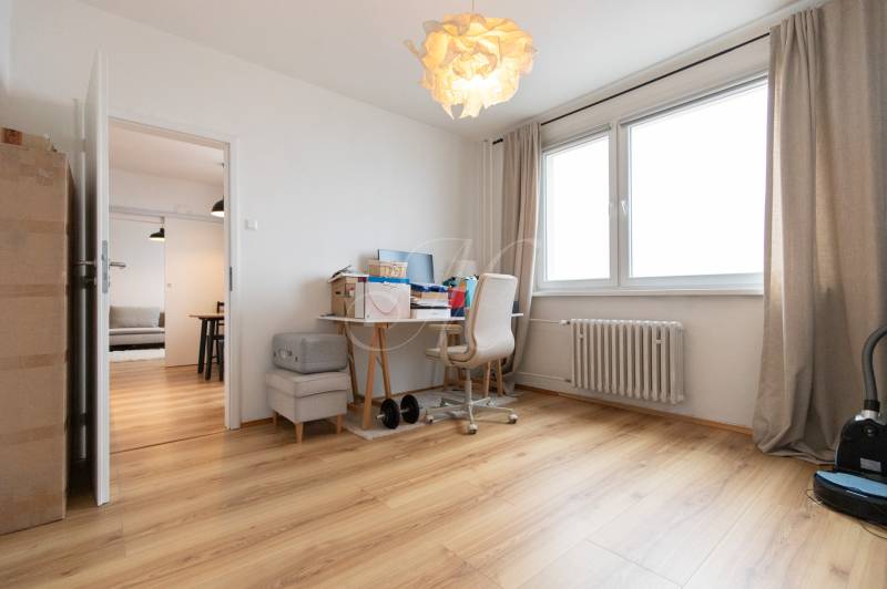 Home office with a desk and wood-patterned flooring in a 3-room apartment.