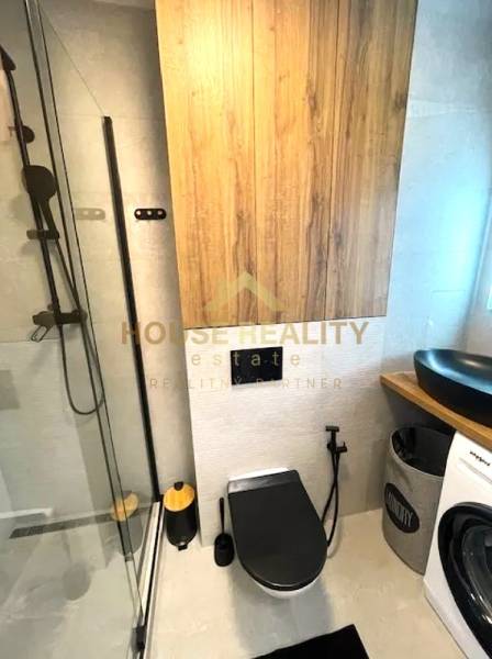 Bathroom with toilet in a 3-room apartment, shower corner, black toilet, washing machine.