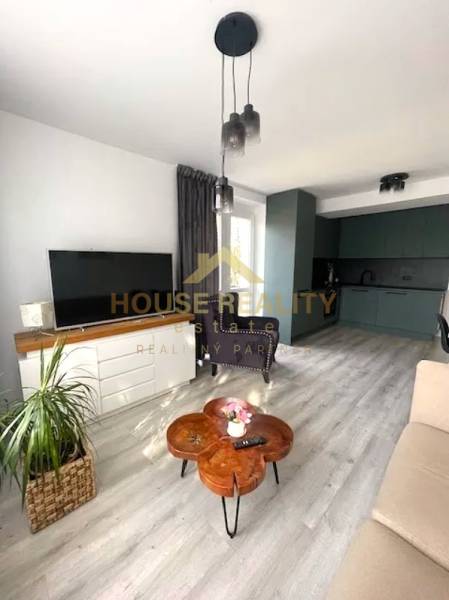 Living room with a TV and kitchen in a 3-room apartment, floor with wooden decor.