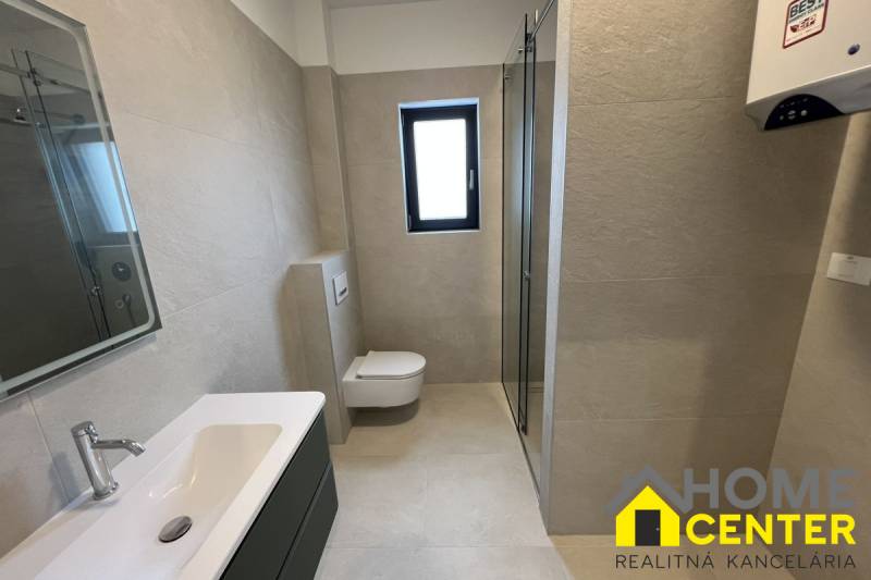 A bathroom in a holiday apartment with a white sink and a shower.