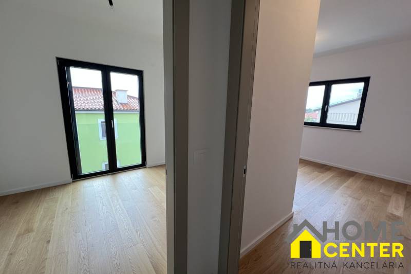 A recreational apartment with wood-patterned flooring and large windows for natural light.