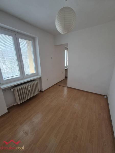 A room in a 2-room apartment with a wooden decor floor and a paper lamp.
