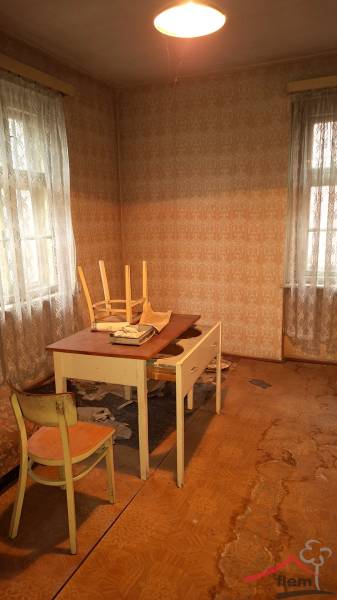A room with a table and chairs, a floor with a wooden decor. Rustic interior of a family house.